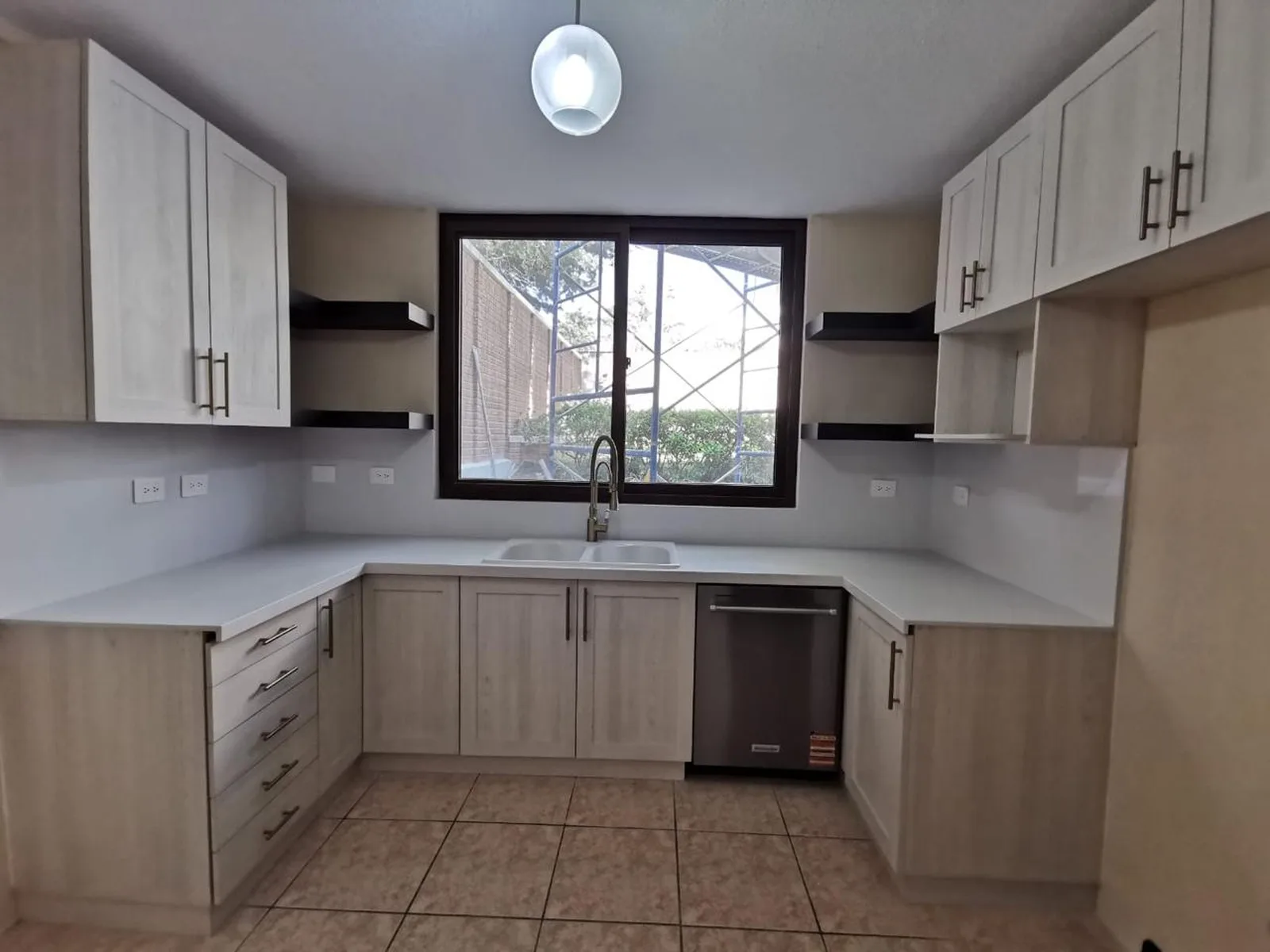 Cocina remodelada con gabinetes modernos, encimeras claras y electrodomésticos integrados.